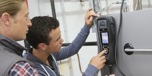 Zwei Anlagenmechaniker die eine Anlage mit einem Messgerät prüfen