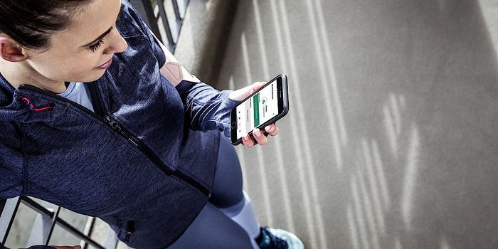 Eine Frau die ein Smartphone in der Hand haelt